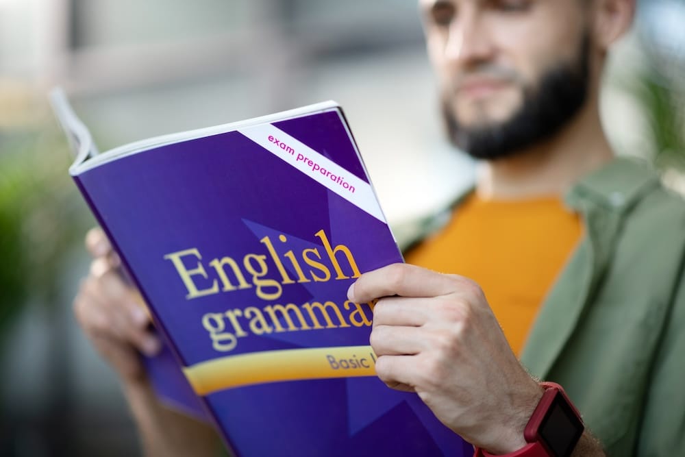 hombre leyendo un libro de ingles para ver Cómo Mejorar tu Vocabulario en Inglés