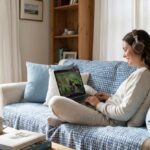 Persona relajada en el sofá con auriculares viendo una serie en inglés